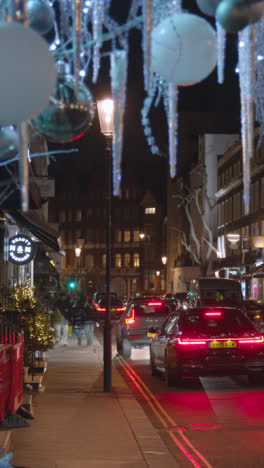 Video-Vertical-De-Tiendas-En-Belgravia-Londres-En-Navidad-Con-Compradores-Y-Trafico-En-La-Noche-4